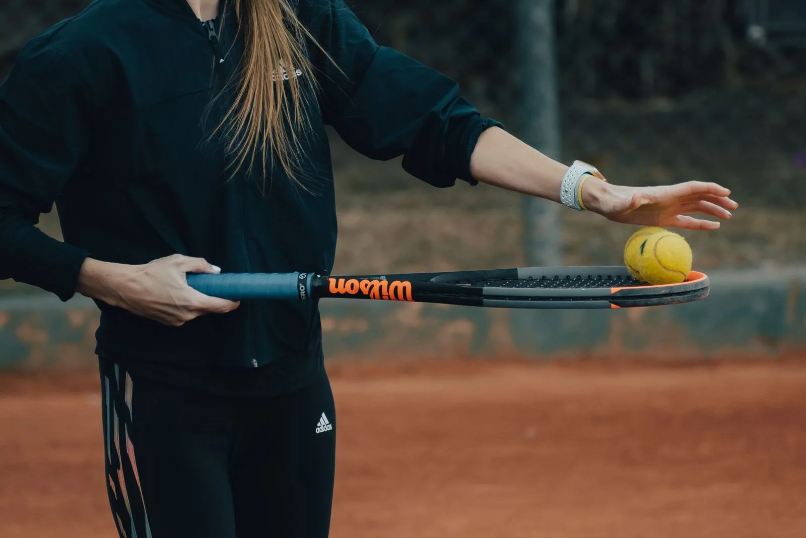 Raquette et balle de tennis tenues sur un court